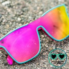 Knockaround Afters Miami Sunglasses with pink lenses and teal frames, close up.