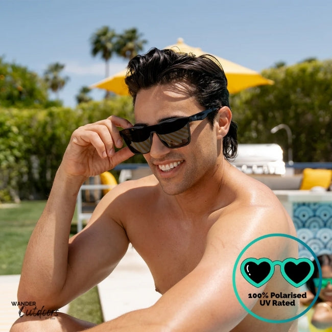 Knockaround Afters Piano Black Sunglasses with black lenses and black frames by the pool, unisex polarised and UV400 Rating.