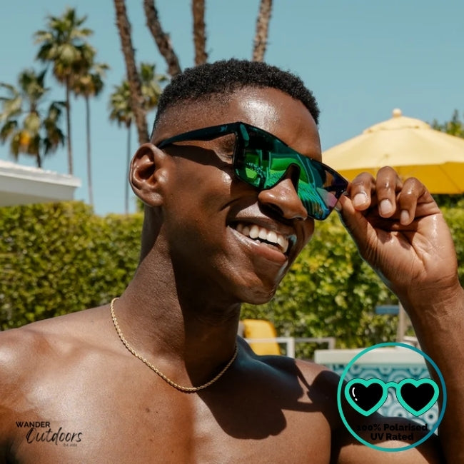Knockaround Afters Ibiza Sunglasses with blue lenses and black frames at the pool, unisex polarised and UV400 Rating.