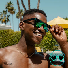 Knockaround Afters Ibiza Sunglasses with blue lenses and black frames at the pool, unisex polarised and UV400 Rating.