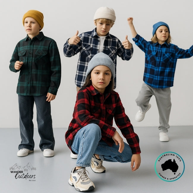 Four children wearing plaid shirts and beanies posing against a light gray background.