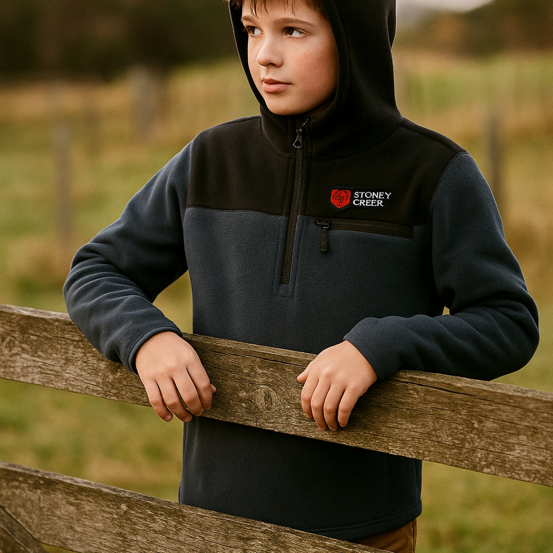 Stoney Creek Kid Wearing Navy and Black Hooded Jumper on the farm
