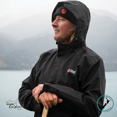 Person wearing a Stoney Creek Recreational (Stow it) Jacket in Black, holding a paddle, standing in front of a body of water.