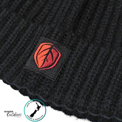 Black knit beanie with a red and orange logo patch on a white background