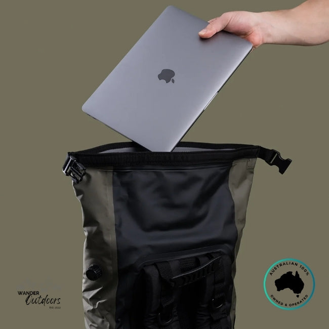Person placing a laptop into a black backpack on a beige background