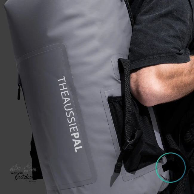 Person holding a gray backpack with 'The Aussie Pal' branding.