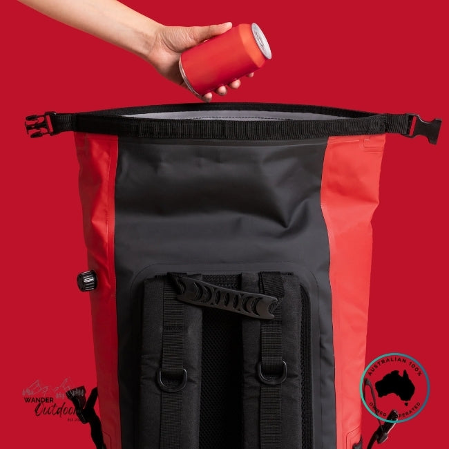 Person opening a black and red backpack with a can against a red background