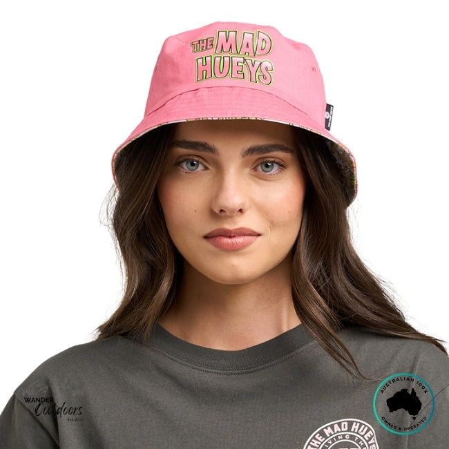 Person wearing a pink 'The Mad Hueys' bucket hat on a white background