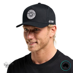 Man wearing a black cap with The Mad Hueys Logo on a white background