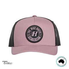 Front view of The Mad Hueys Living Hueys Twill Trucker Hat in mauve and black with round Surf Fish Party logo patch.