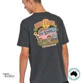 Back angled view of The Mad Hueys Roadie Tee showing full “Havin’ a Roadie” graphic featuring a ute, palm trees, and sunset scene.