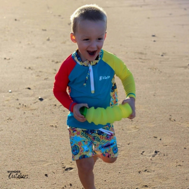 A boy on the beach wearing the aussie animalia rashie running on the beach