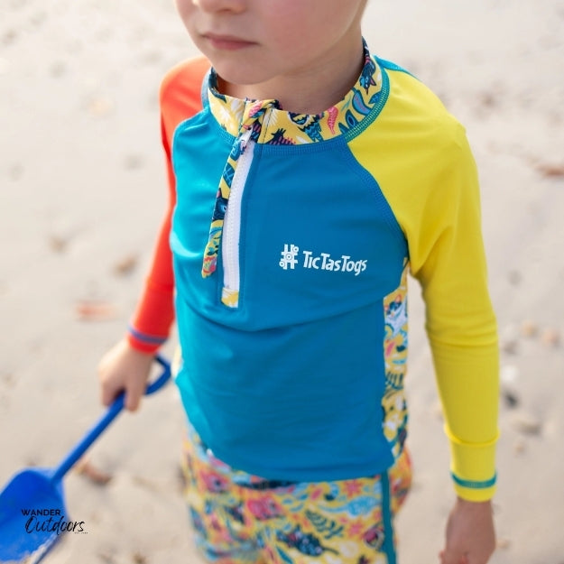 A boy on the beach wearing the aussie animalia rashie with a shovel.