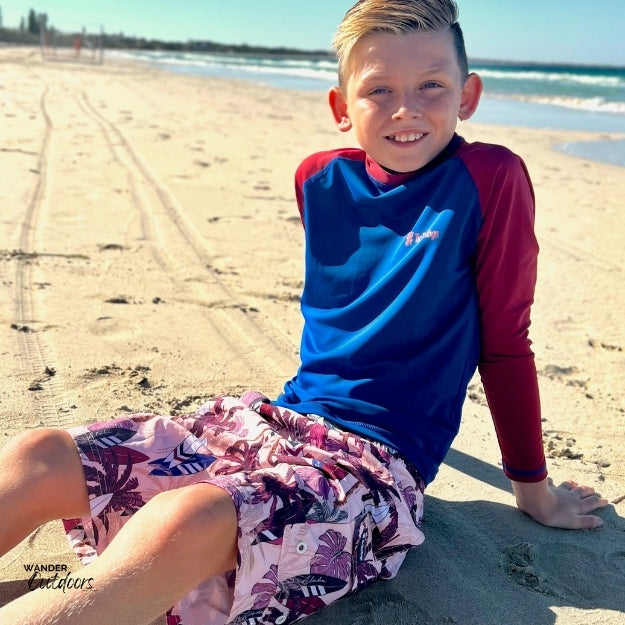 Chilling on the sand in his surfs up rashie
