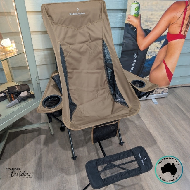 Brown Dhubite Outdoors Compact Camp Chair paired with matching black mesh foot rest on display indoors, showing compatibility and ergonomic setup.