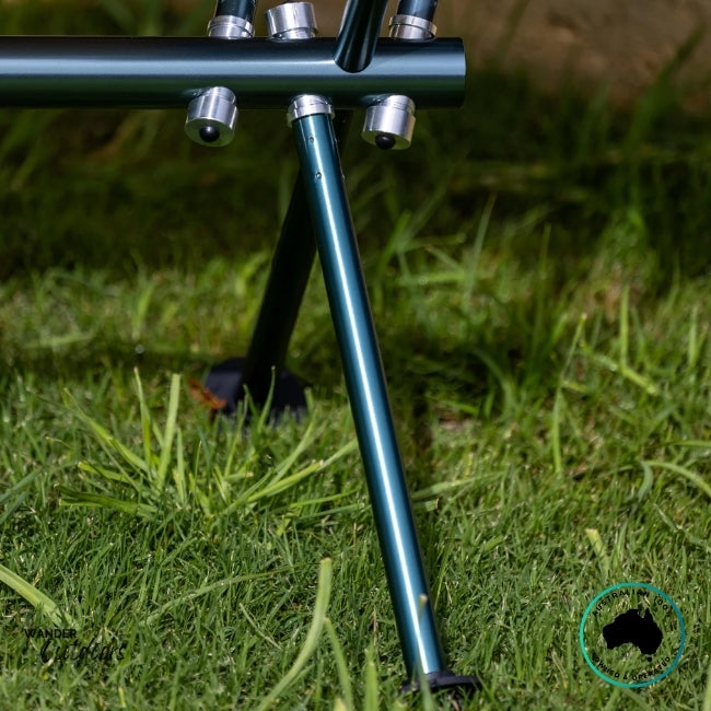 Close-up of the Dhubite Outdoors camp chair frame showing high-strength 7075-grade aluminium tubing with precision connectors on green grass.