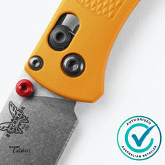Close-up of a folding knife with orange handle and visible brand logo on a white background.