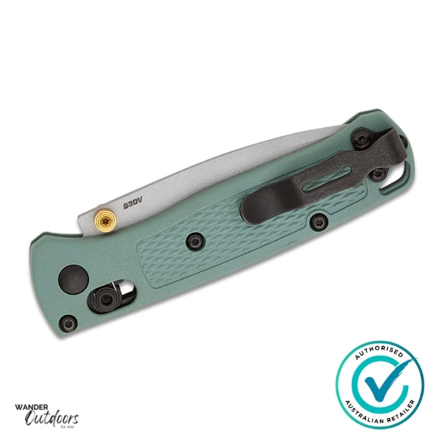 Green folding knife with a white blade on a white background, featuring Wander Outdoors branding.