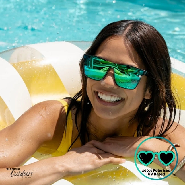 Knockaround Afters Ibiza Sunglasses with blue lenses and black  frames by the pool, unisex polarised and UV400 Rating. 