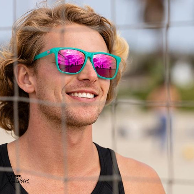 Unisex affordable Knockaround Fast Lanes Sport Sunglasses Aquamarine Fuchsia Male wearing on beach volleyball court