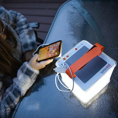 LuminAID PackLite Titan 2-in-1 Power Lantern Charging smart phone and being used as a light