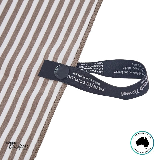 Close-up of snap-lock hanging loop on Newlyfe Signature Piha Brown Towel with woven branding label.