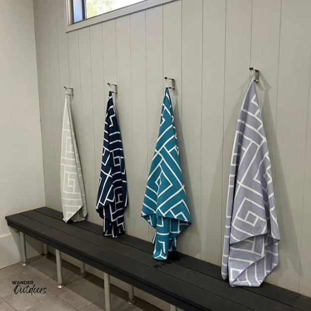 Newlyfe Waffle Weave Bath Towel Grey, Navy, Teal & Blue hanging in camping shower block