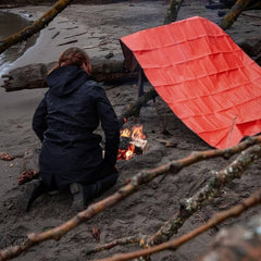 Survive Outdoors Longer All Season Blanket being used as a wind break shelter