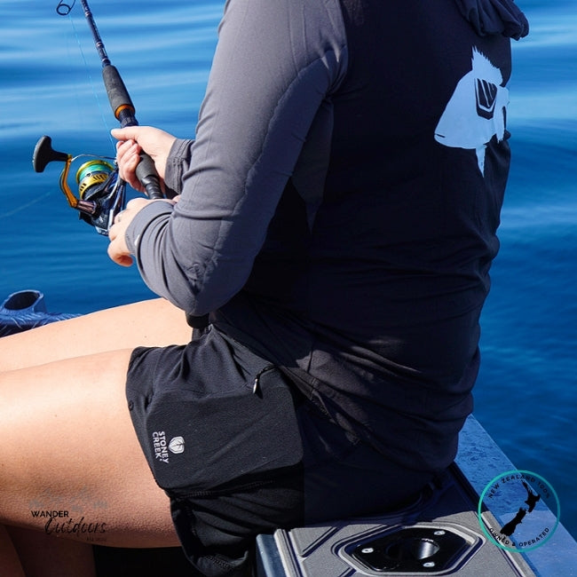 Person fishing on a boat with a blue water background