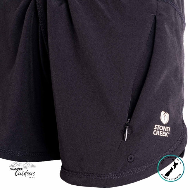 Close-up of a black jacket with a Stone Creek logo on the sleeve, featuring brand logos at the bottom.