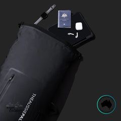 Black backpack with travel items on a black background