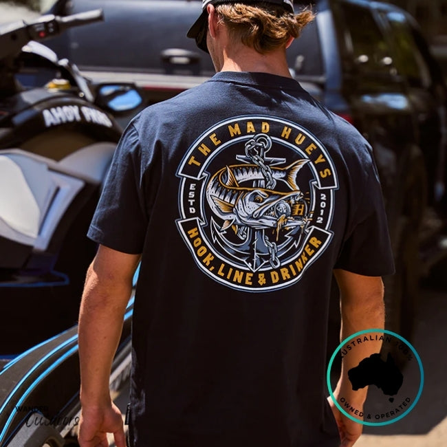 Person wearing a navy t-shirt with a logo and text, standing next to a jetski.