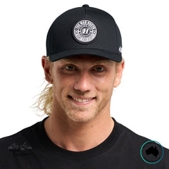Man wearing a black cap with The Mad Hueys Logo front on, on a white background