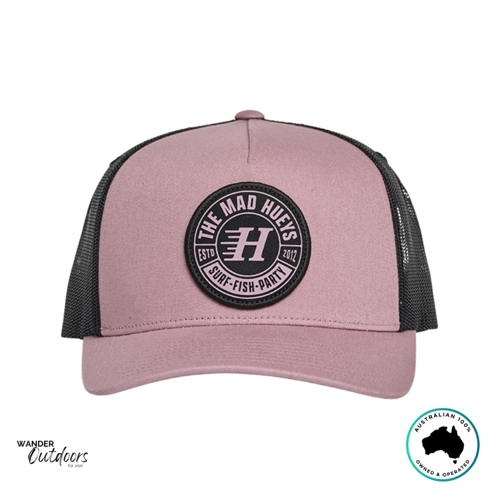 Front view of The Mad Hueys Living Hueys Twill Trucker Hat in mauve and black with round Surf Fish Party logo patch.