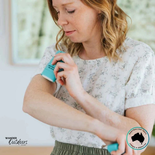 Woman applying Wotnot Naturals SPF 50 Zinc Sunscreen Stick to her arm indoors.